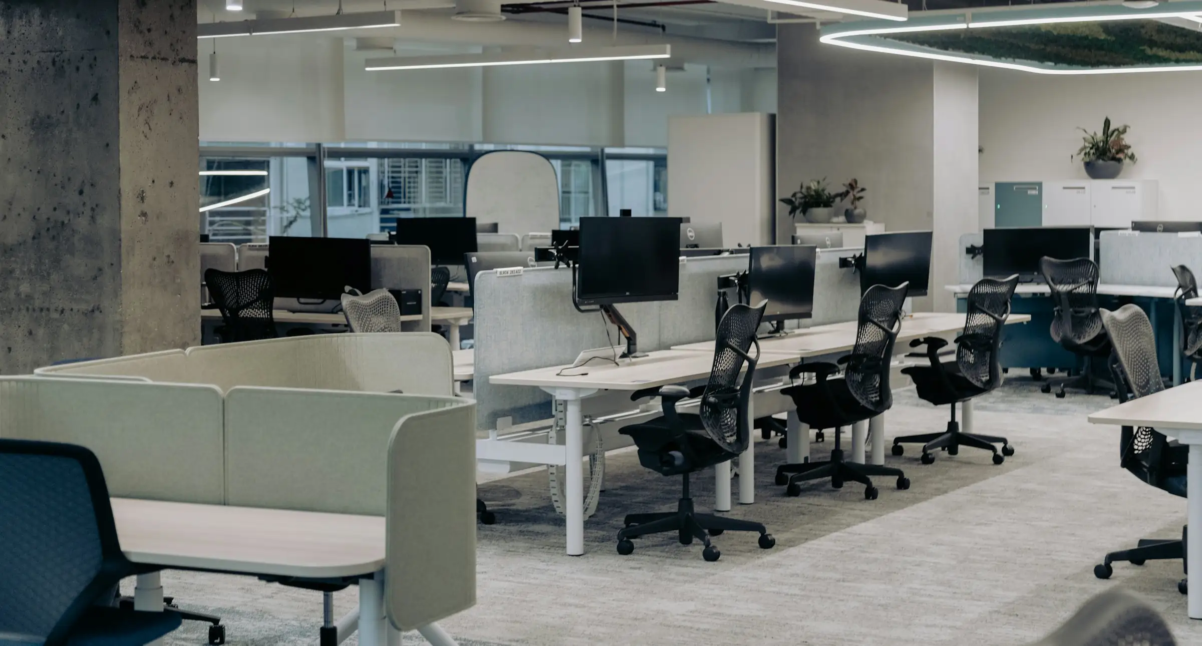 Open-plan office fitted with workstations, task chairs and soft seating