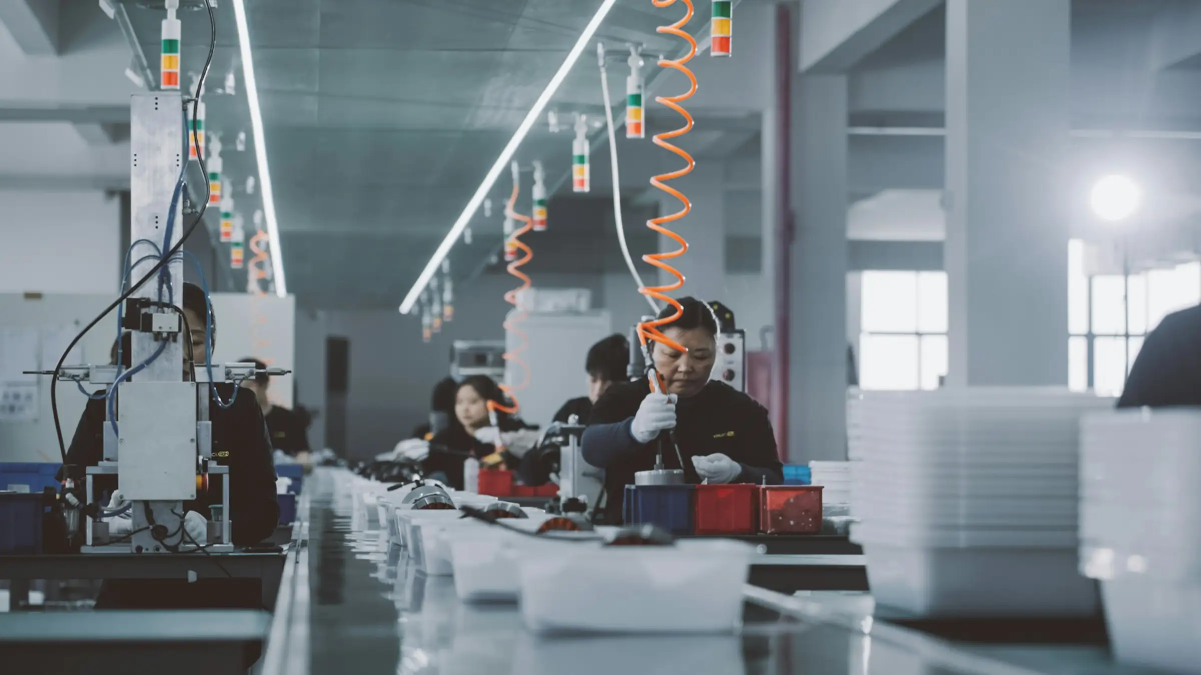 Workers assembling products along a contract manufacturing assembly line