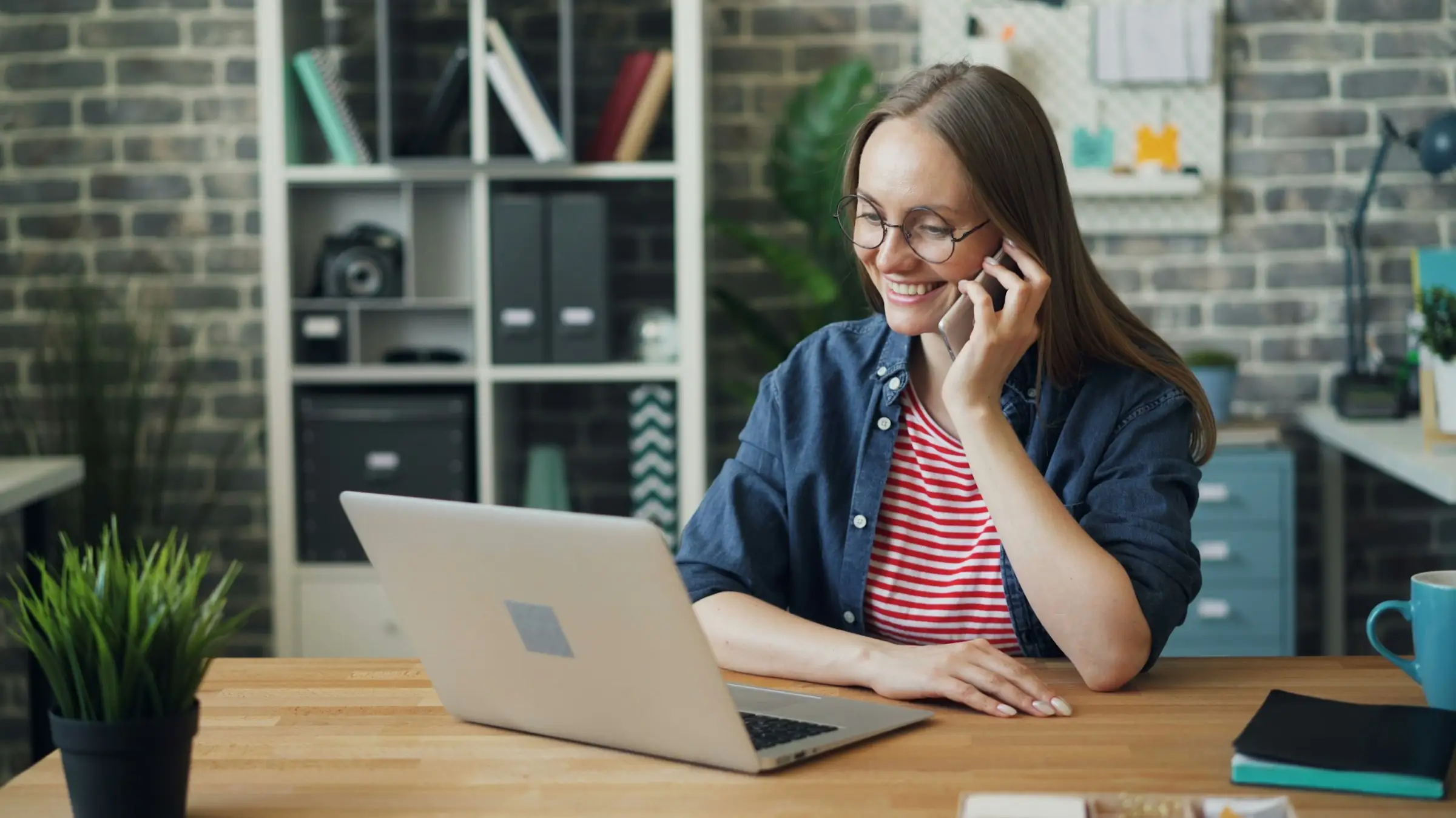 Salesperson on a phone call at her laptop in a bright office