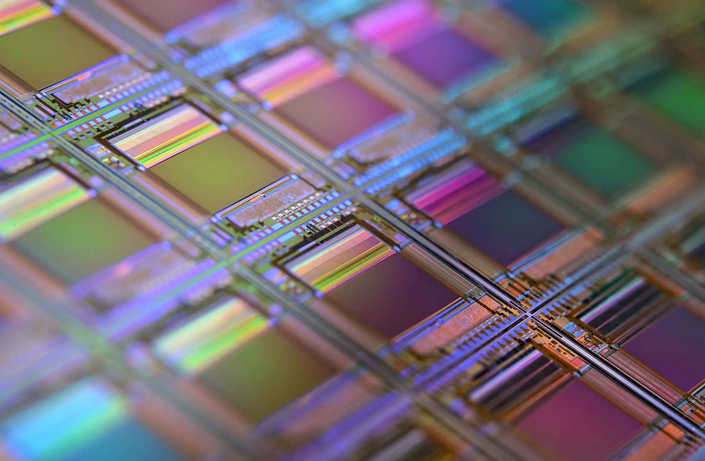 Close-up of a silicon wafer with an iridescent grid of chips